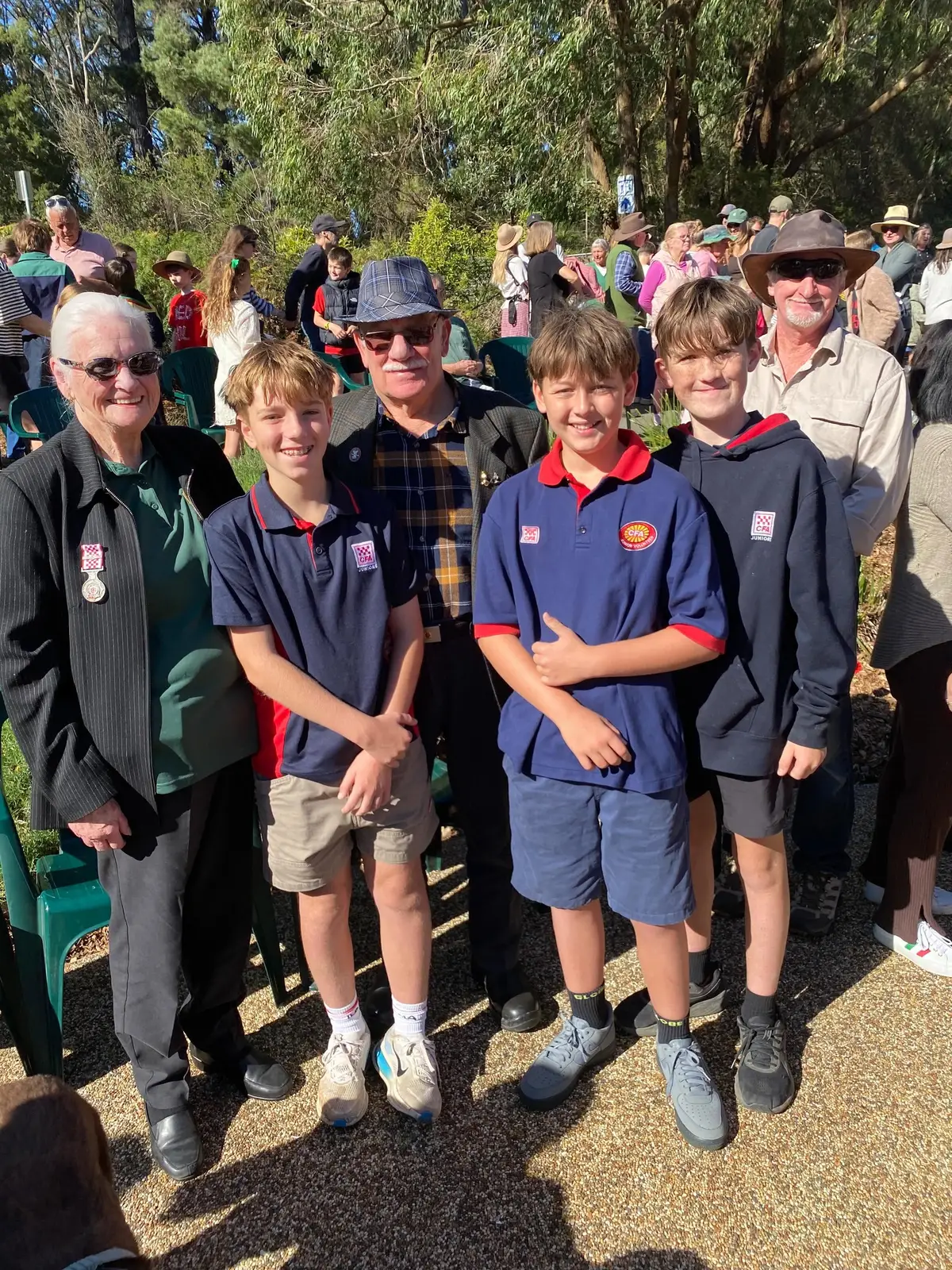 Juniors in CFA polo shirts with brigade members at a community ANZAC Day service